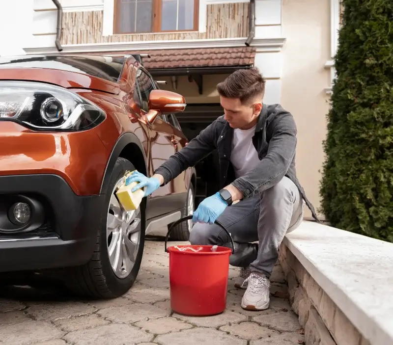 Lavage auto à domicile Castres-Gironde : professionnel intervenant sur un véhicule